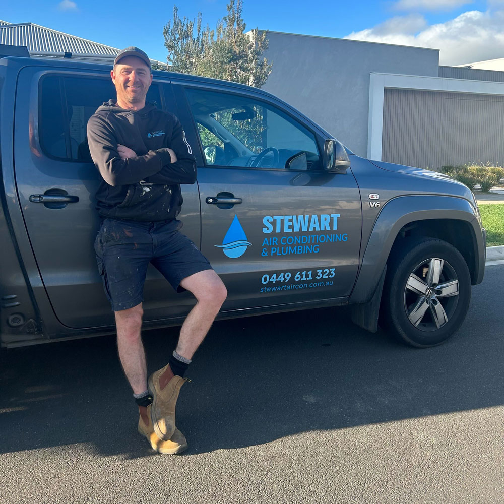 Andrew Stewart, owner-operator of Stewart Air Conditioning & Plumbing, beside the work ute